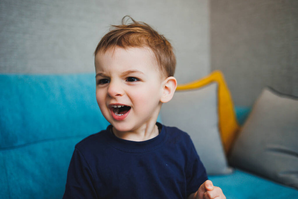 Emozioni sul viso di un bambino di due anni, un bambino emotivo. Un ragazzo con diverse smorfie sul viso. - Foto, immagini