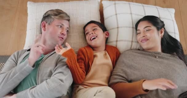Mom, dad and kid lying on bed, pillows and playing, game or bedtime fun with family, parents and kid on living room floor. Top view, happy and quality time to relax, bond or father tickling son. - Footage, Video