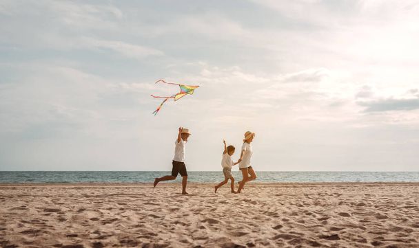 Happy asian family enjoy the sea beach. father, mother and daughter having fun playing beach in summer vacation on the ocean beach. Happy family with vacation time lifestyle concept. - Fotoğraf, Görsel