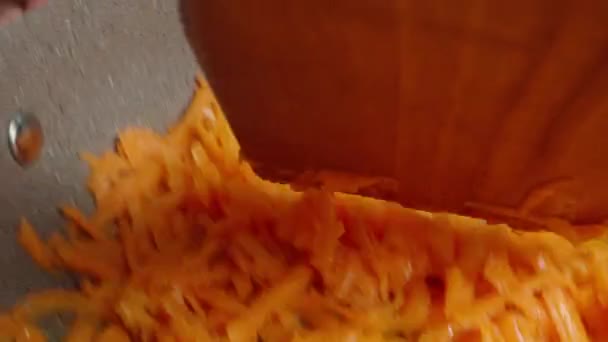Stir with a wooden spatula, carrots fried in a frying pan, macro shot, POV - Filmati, video