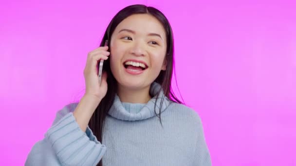 Aziatische vrouw, telefoongesprek en blij voor het praten in de studio voor communicatie, contact en chat door achtergrond. Japanse student, gen z meisje en smartphone voor gesprek met glimlach op mobiel netwerk. - Video