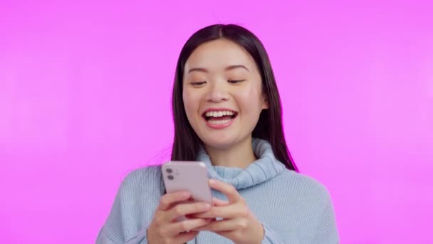 Asyalı kadın, telefon ve mesajlaşma stüdyoda kahkahalarla sosyal ağ uygulaması, mim ve pembe arka plan ile komik. Japon öğrenci, akıllı telefon ve gülümseme ile sohbet, komik yazı ve blog ile daktilo. - Video, Çekim