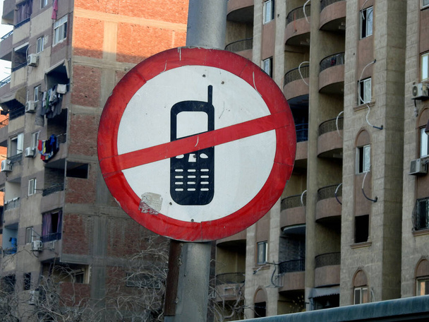 Kairó, Egyiptom, 2023. június 23.: Vezetés közben tilos mobiltelefon használata, a forgalmi tábla azt mutatja, hogy vezetés közben korlátozott és tiltott mobiltelefon használata, beleértve a beszélgetést, az olvasást és az SMS-ezést - Fotó, kép