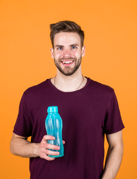 healthy lifestyle. keep water balance in body. hydration. handsome young man drink water. casual summer fashion style. guy hold plastic bottle. man relax after sport. feeling thirsty. - Foto, imagen