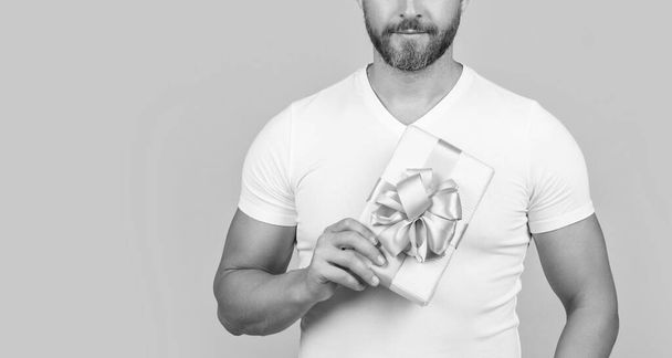 man hold present box isolated on yellow background with copy space. man hold present box in studio. man with present box for holiday. photo of man holding occasion present box. - Foto, immagini