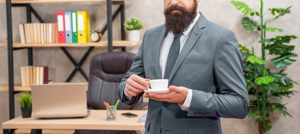cropped brutal ceo in businesslike suit hold morning coffee cup at the office, lunch break. - Foto, Imagen