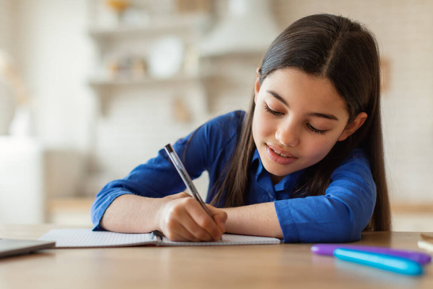 E-öğrenme. Evde dizüstü bilgisayarla ders çalışırken not yazan Arapça okullu kız. Çevrimiçi ödev yapan sevimli çocuk ve İnternet Dersinden Bilgi Alma Bilgisayarın Yakınındaki - Fotoğraf, Görsel