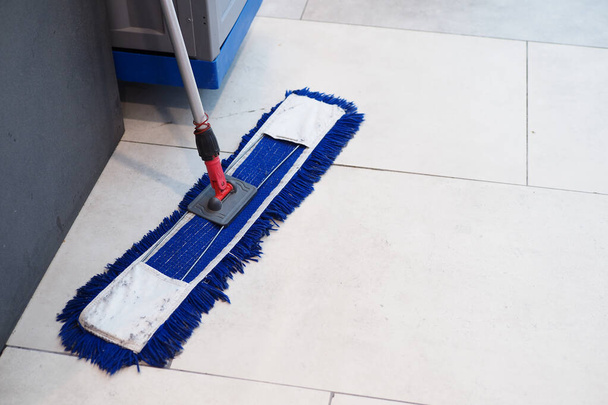 cleaning tiles floor with mop . - Zdjęcie, obraz