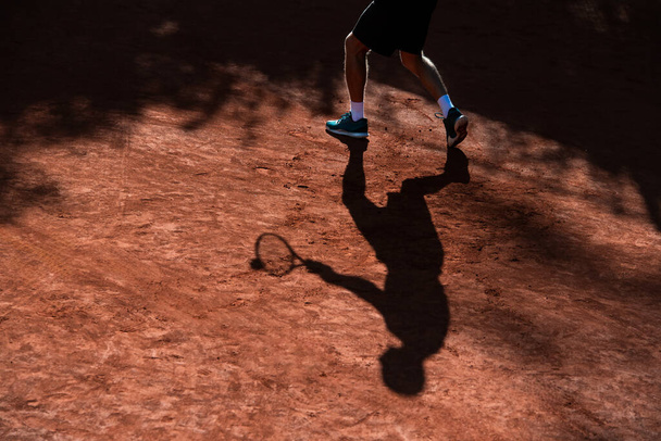 Jogador de tênis sombra em um campo de tênis de barro. Horizontal esporte tema cartaz, cartões de saudação, cabeçalhos, site e app - Foto, Imagem