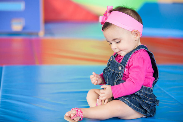 Kauniin kymmenen kuukauden tyttövauvan muotokuva värikkäällä taustalla. Varhainen stimulaatio pikkulapsille käsite. - Valokuva, kuva