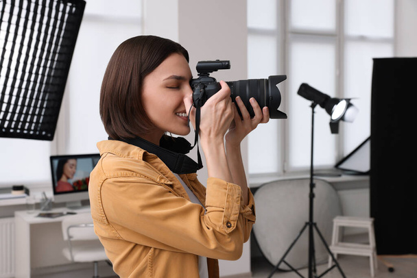 Professional photographer taking picture in modern photo studio - Фото, изображение