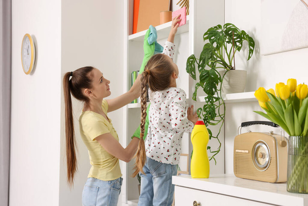 Spring cleaning. Mother and daughter tidying up together at home - Foto, Imagen
