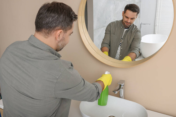 Man in rubber gloves with sprayer in bathroom - Fotoğraf, Görsel