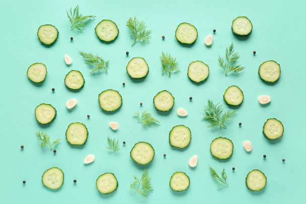 Slices of cucumber with dill and garlic on turquoise background - 写真・画像