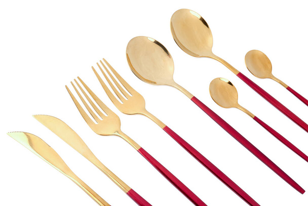 Golden set of cutlery with red handles on white background - Fotografie, Obrázek