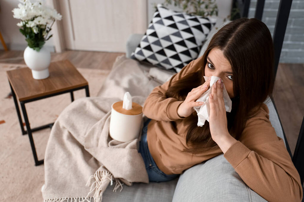 Allergic young woman with tissue at home - Photo, Image