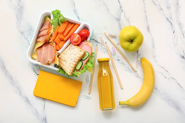 Χαρτικά, ποτά και μεσημεριανό κουτί με νόστιμο φαγητό σε λευκό φόντο grunge - Φωτογραφία, εικόνα