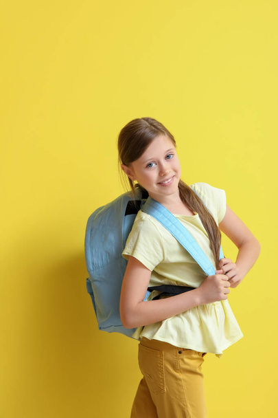 Κοριτσάκι με σακίδιο σε κίτρινο φόντο - Φωτογραφία, εικόνα