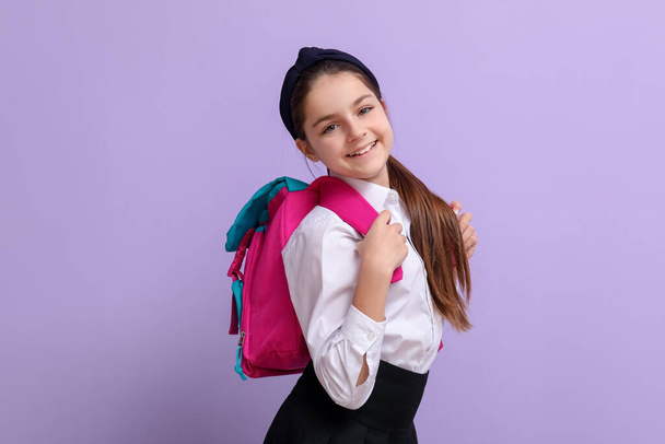 Pequena estudante com mochila no fundo lilás - Foto, Imagem