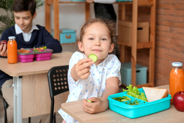 Little girl eating lunch in classroom - 写真・画像