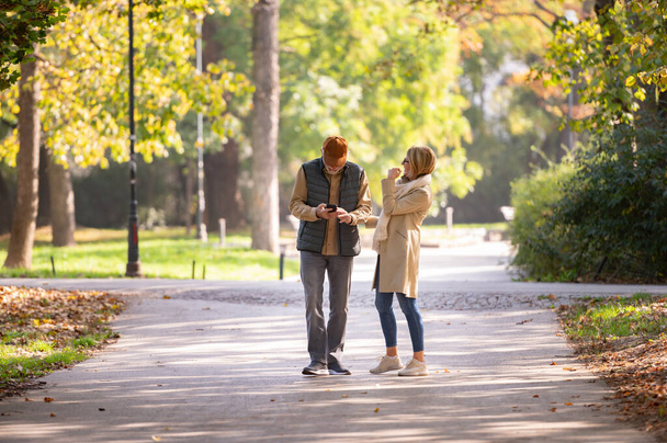 Onnellinen pari kävelee syksyllä puistossa
 - Valokuva, kuva