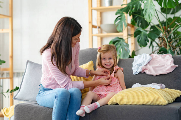 happy mother and daughter in living room spending time together - Photo, image