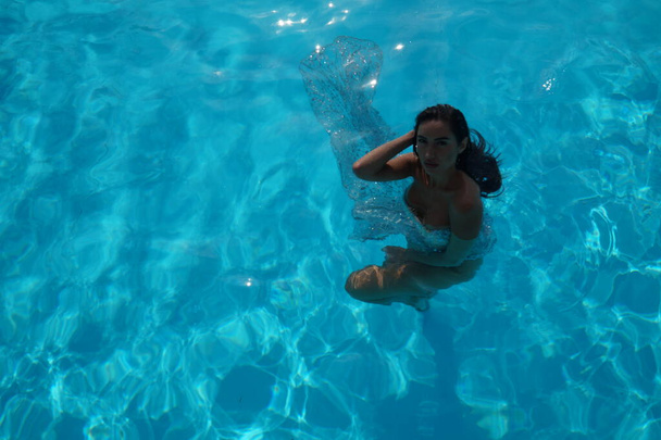 sexy ragazza in un abito trasparente in una piscina   - Foto, immagini