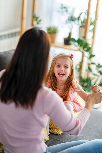 happy mother and daughter in living room spending time together - Photo, Image