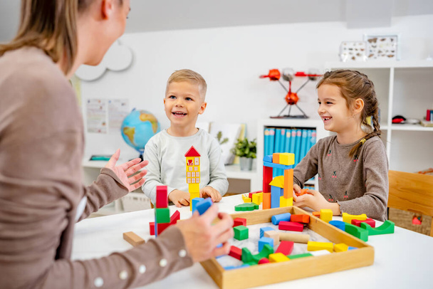 Niños de jardín de infantes jugando con bloques de construcción de colores. Ambiente de aprendizaje saludable. Aprender a través del juego. - Foto, imagen