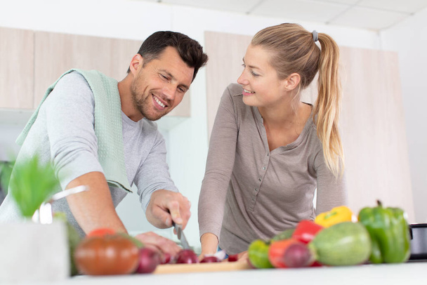 smiling young couple cooking food in the kitchen - Foto, Bild