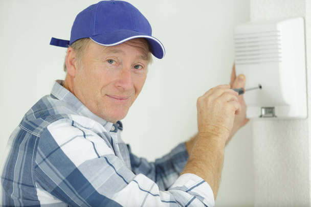 happy man installing an electric hand dryer - Zdjęcie, obraz