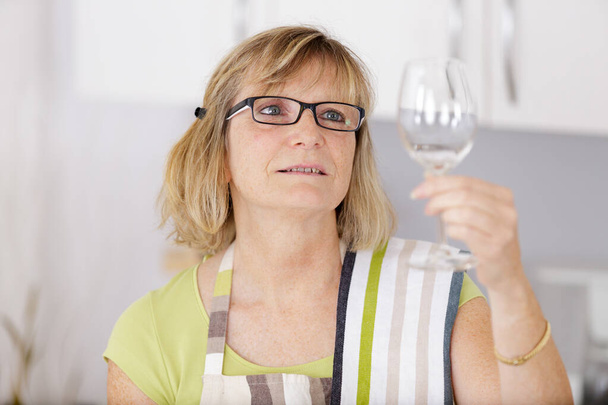 woman washes wineglasses in kitchen - Foto, Imagen