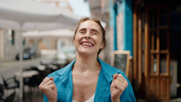 Young woman smiling confident surprised at street - Φωτογραφία, εικόνα