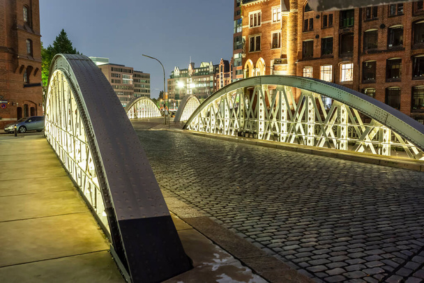 Speicherstadt in Hamburg bei Nacht mit Kopfsteinpflaster und Eisenbrücke - Foto, Bild