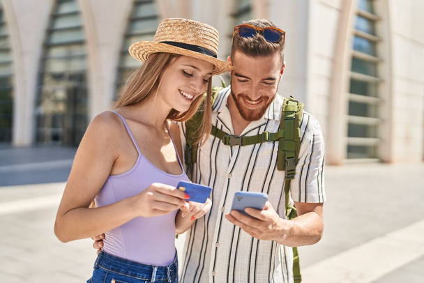 Άνδρας και γυναίκα τουριστικό ζευγάρι χρησιμοποιώντας smartphone και πιστωτική κάρτα στο δρόμο - Φωτογραφία, εικόνα