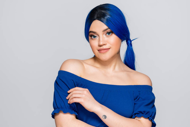 Schönheitstrends, gefärbte Haare, Sommermode, junge Frau mit nackten Schultern posiert in heller Bluse auf grauem Hintergrund, blaue Haarfarbe, Frisur, weibliches Modell, Make-up und Schönheit  - Foto, Bild