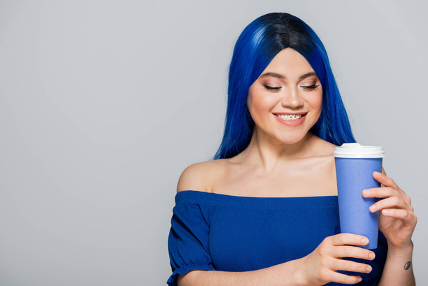 papírový šálek, šťastná mladá žena s modrými vlasy a očima drží kávu jít na šedé pozadí, odnést, kofein, energie, tetování, zářivé barvy, vlastní vyjádření, individualismus  - Fotografie, Obrázek