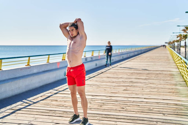 Young man stretching arms at seaside - Photo, Image