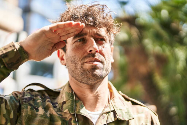Young man army soldier doing militar salute at park - 写真・画像
