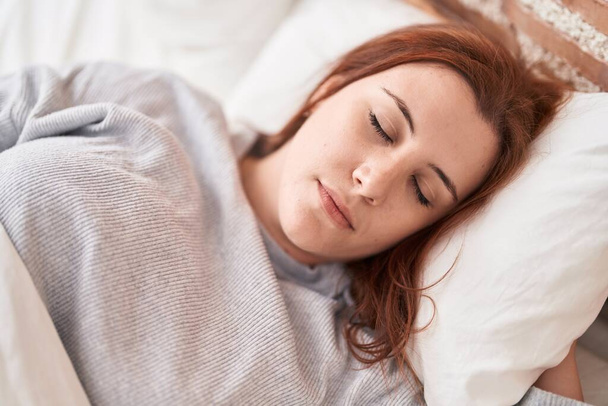 Νεαρή όμορφη συν μέγεθος γυναίκα ξαπλωμένη στο κρεβάτι κοιμάται στο υπνοδωμάτιο - Φωτογραφία, εικόνα