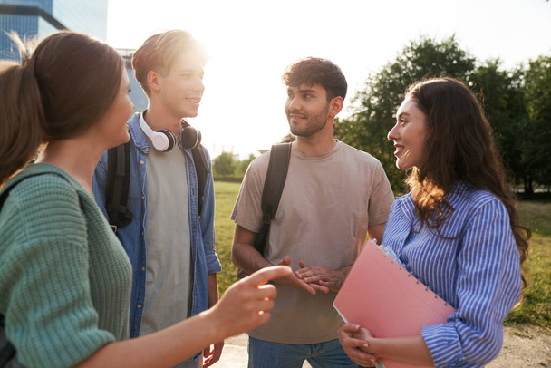 Ryhmä valkoihoisten opiskelijoiden seisoo yliopiston kampuksella ja jutteleminen - Valokuva, kuva