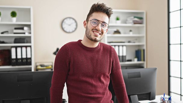Giovane ispanico uomo d'affari lavoratore sorridente fiducioso a ufficio - Foto, immagini