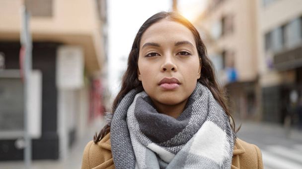 Junge schöne hispanische Frau steht mit ernstem Gesichtsausdruck auf der Straße - Foto, Bild