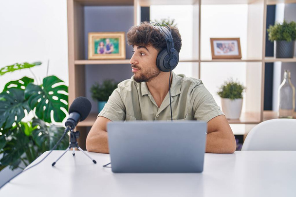 Arab man with beard working at the radio looking to side, relax profile pose with natural face with confident smile.  - Φωτογραφία, εικόνα