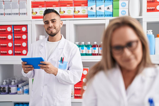 Hombre y mujer farmacéutico usando touchpad trabajando en farmacia - Foto, Imagen