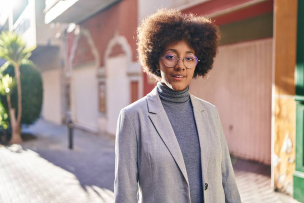 African american woman executive standing with relaxed expression at street - Foto, Bild