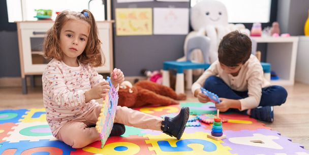 Чарівний хлопчик і дівчинка грають зі словниковою головоломкою в дитячому саду
 - Фото, зображення