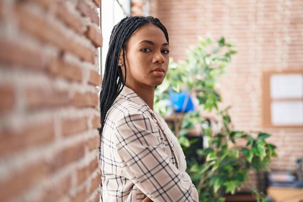 African American επιχειρηματίας γυναίκα ακουμπά στον τοίχο με σοβαρή έκφραση στο γραφείο - Φωτογραφία, εικόνα