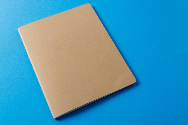 Close up of beige notebook with copy space on blue background. Literature, reading, writing, leisure time and books. - Foto, Imagen