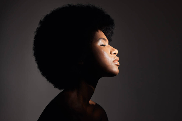 Face shadow, light and black woman with skincare, natural beauty glow and peace after cosmetics treatment. Aesthetic makeup profile, afro and African studio person with self care on grey background. - Foto, Imagen